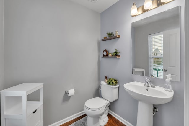 bathroom featuring hardwood / wood-style flooring and toilet