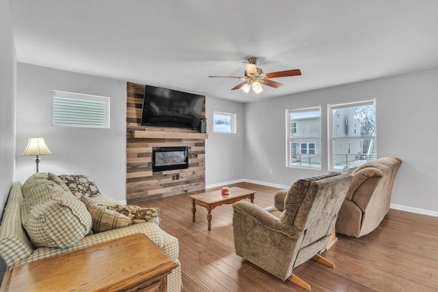 living room featuring hardwood / wood-style flooring, ceiling fan, plenty of natural light, and a fireplace