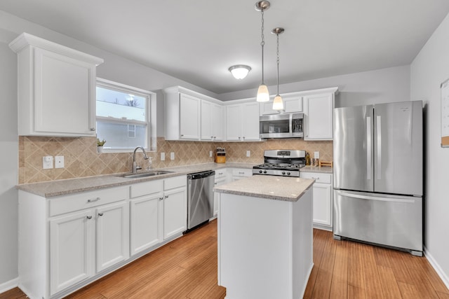 kitchen featuring a kitchen island, sink, white cabinetry, and stainless steel appliances