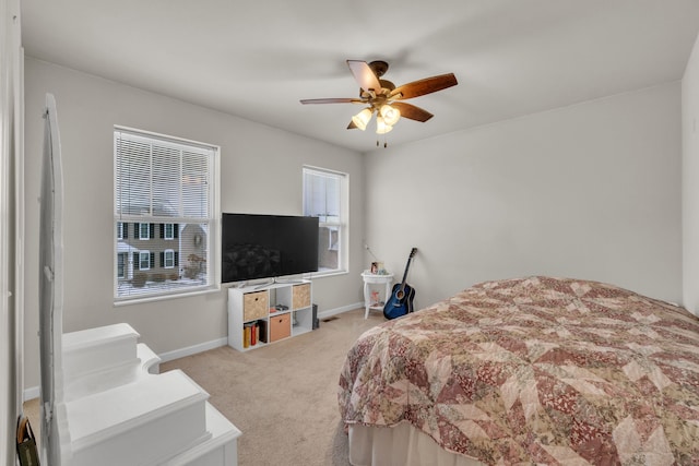 bedroom featuring carpet flooring, ceiling fan, and multiple windows