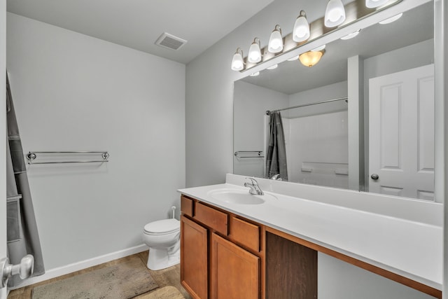 bathroom featuring vanity, toilet, and walk in shower