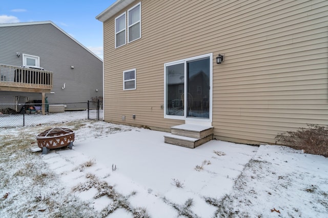 snow covered rear of property featuring an outdoor fire pit