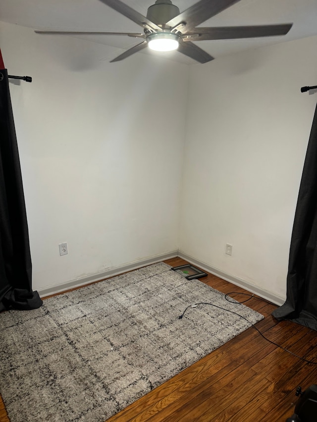 spare room with dark hardwood / wood-style floors and ceiling fan