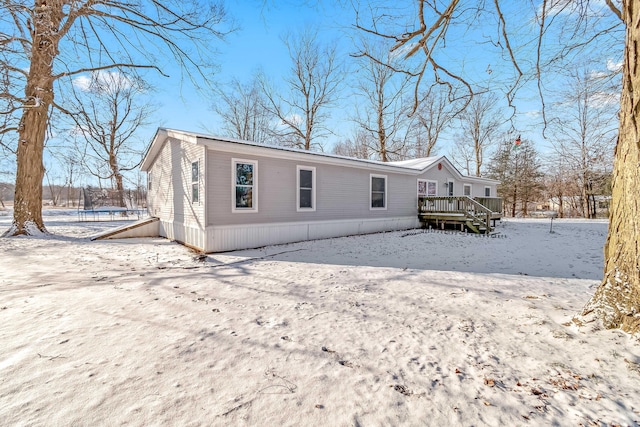 snow covered house featuring a deck