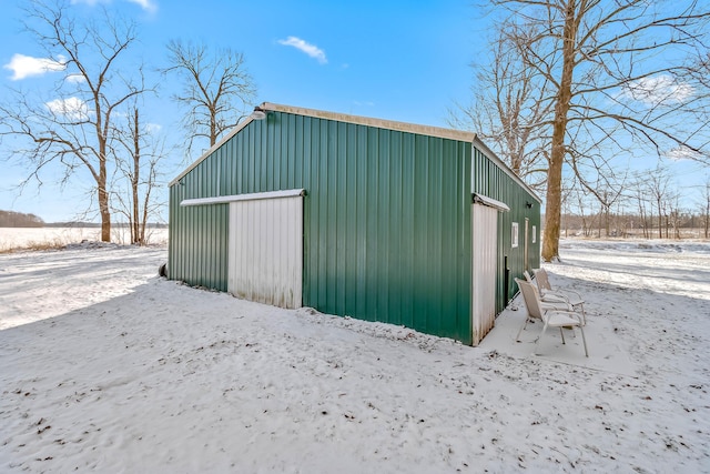 snow covered structure featuring a garage