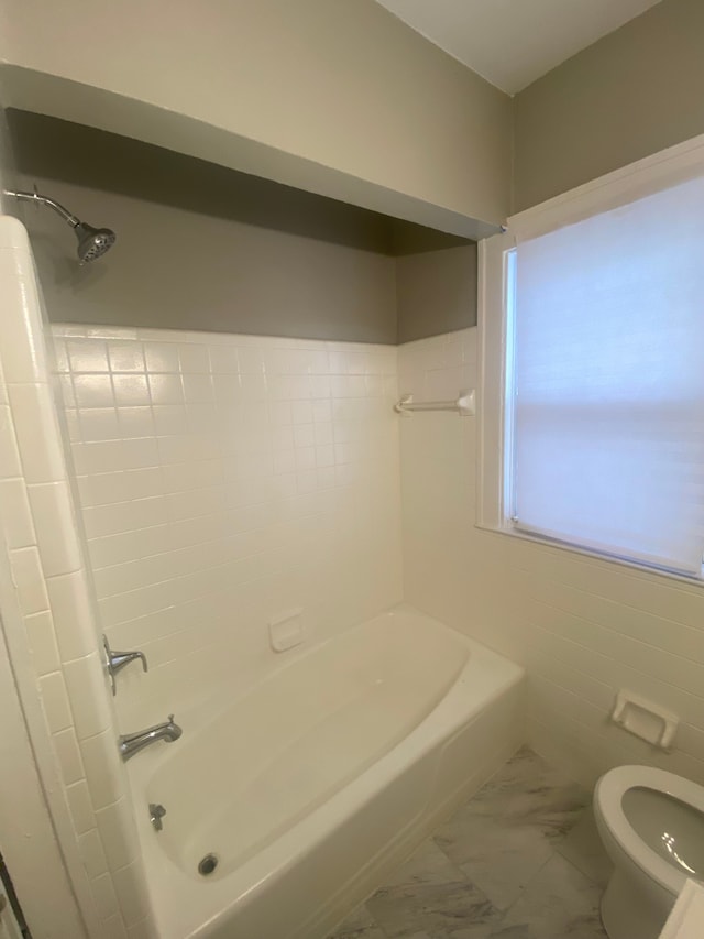 bathroom featuring toilet and bathing tub / shower combination