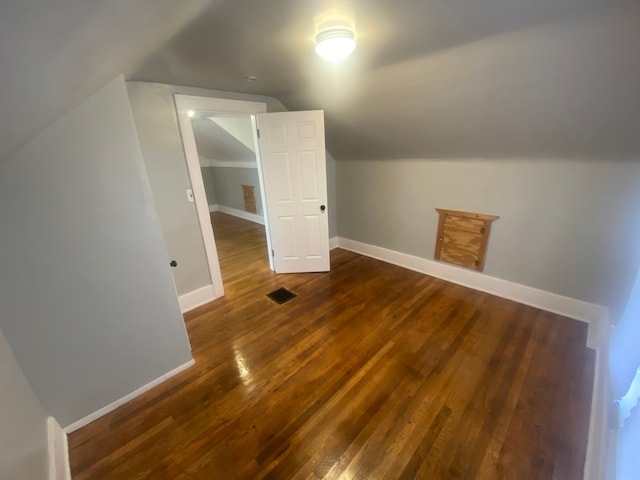 additional living space with dark wood-type flooring and lofted ceiling