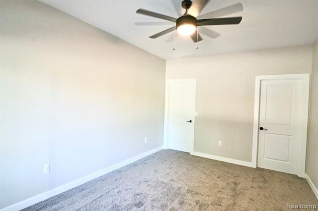 carpeted spare room with ceiling fan