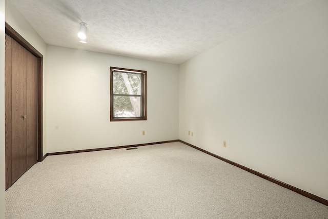 unfurnished bedroom with a closet, carpet floors, and a textured ceiling