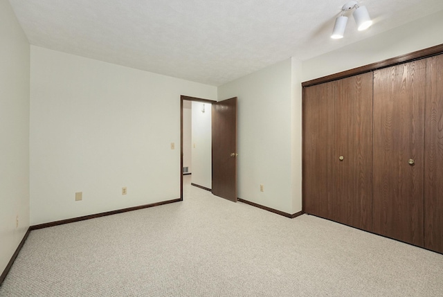 unfurnished bedroom with light carpet and a closet