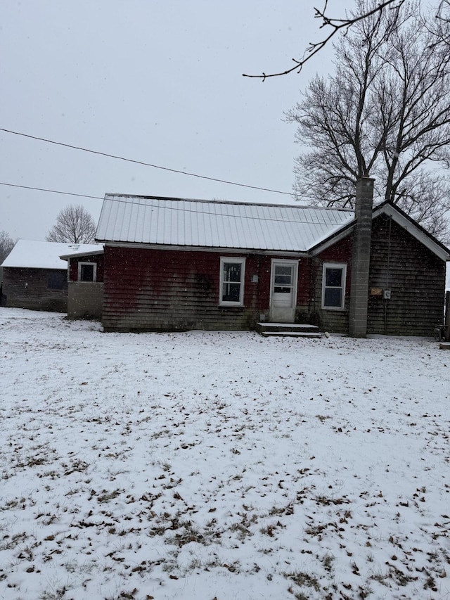 view of snow covered back of property