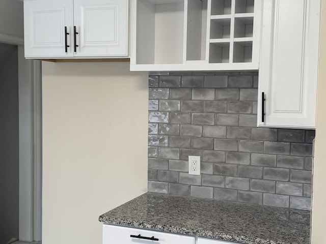 kitchen with tasteful backsplash, white cabinetry, and dark stone counters