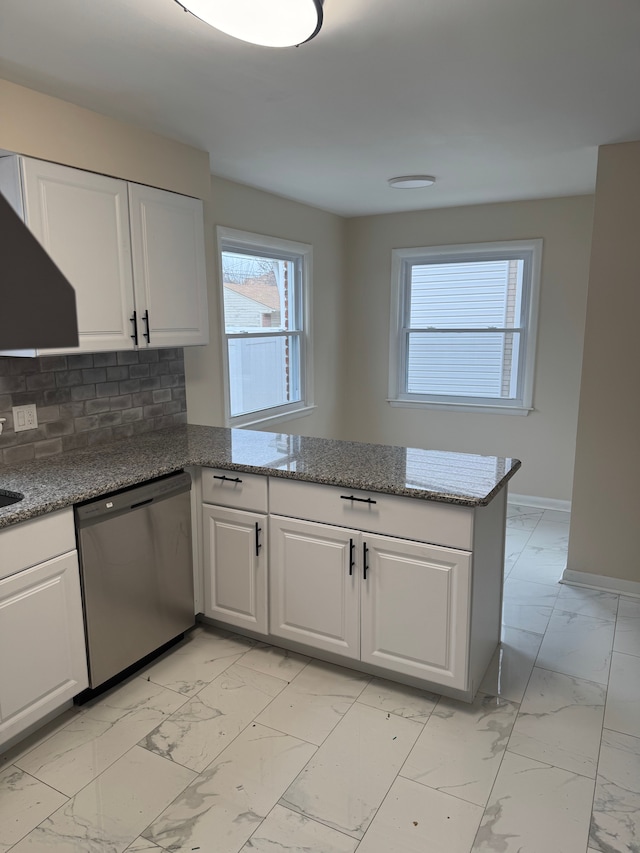 kitchen with white cabinets, dishwasher, kitchen peninsula, and backsplash