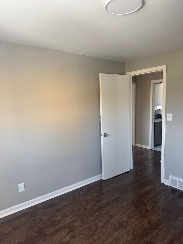 unfurnished room with dark hardwood / wood-style flooring