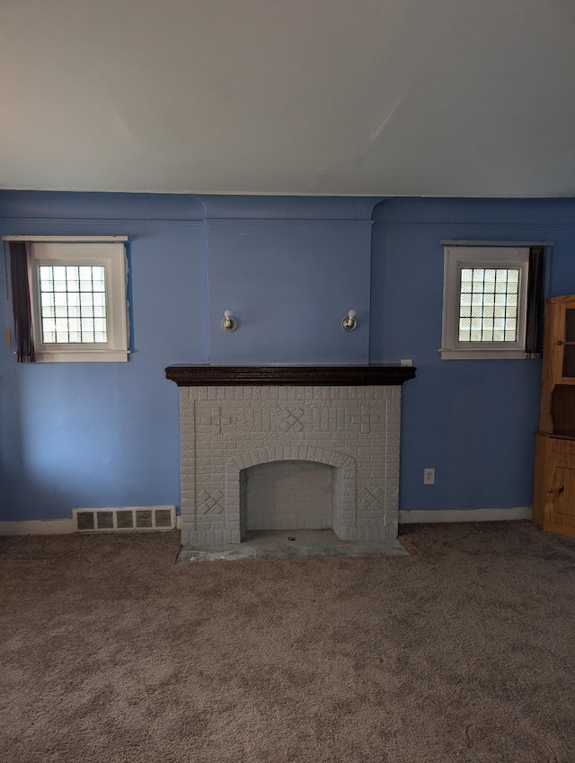 unfurnished living room with carpet flooring and a brick fireplace