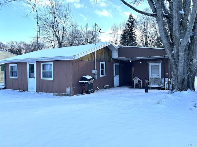 view of snow covered rear of property