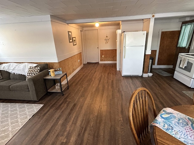 living room with dark hardwood / wood-style flooring and wooden walls