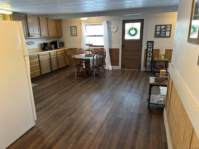 kitchen featuring wood walls, white refrigerator, and dark hardwood / wood-style flooring