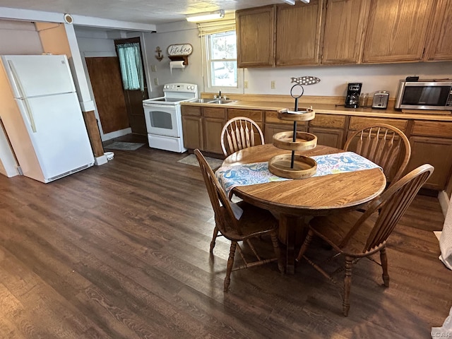 kitchen with white appliances, dark hardwood / wood-style floors, and sink