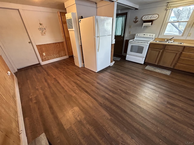 kitchen featuring wood walls, sink, dark hardwood / wood-style floors, and white appliances