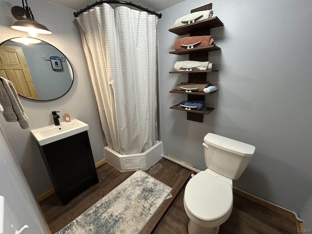 bathroom featuring a shower with shower curtain, hardwood / wood-style floors, vanity, and toilet