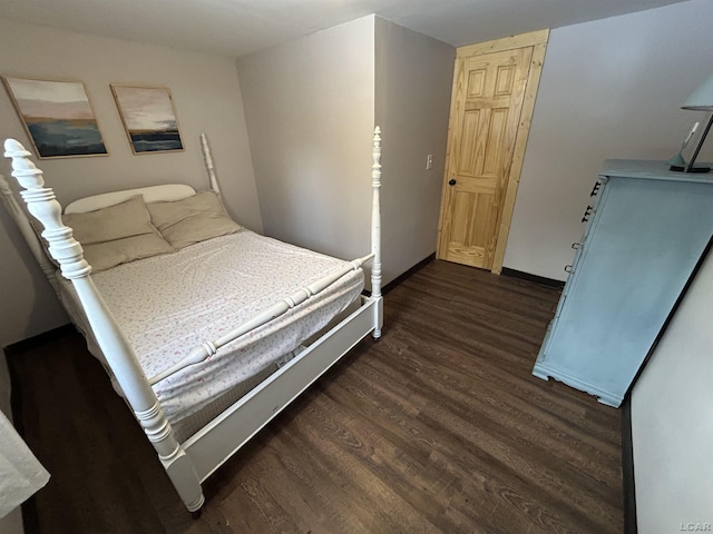 bedroom with dark hardwood / wood-style floors