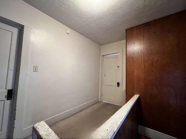 hall featuring a textured ceiling