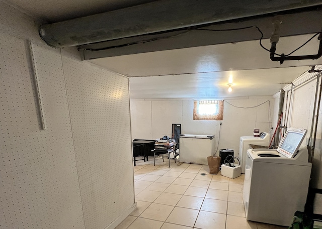 laundry area with washing machine and dryer and light tile patterned floors