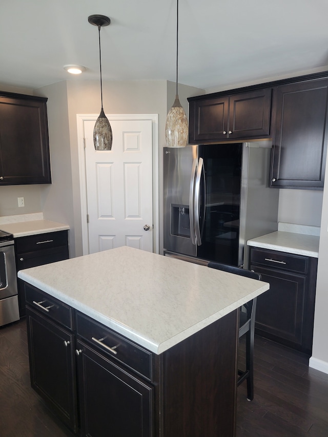 kitchen with a center island, decorative light fixtures, stainless steel fridge, dark hardwood / wood-style flooring, and stove