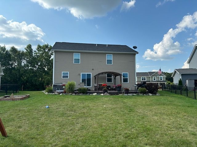 rear view of property featuring a yard