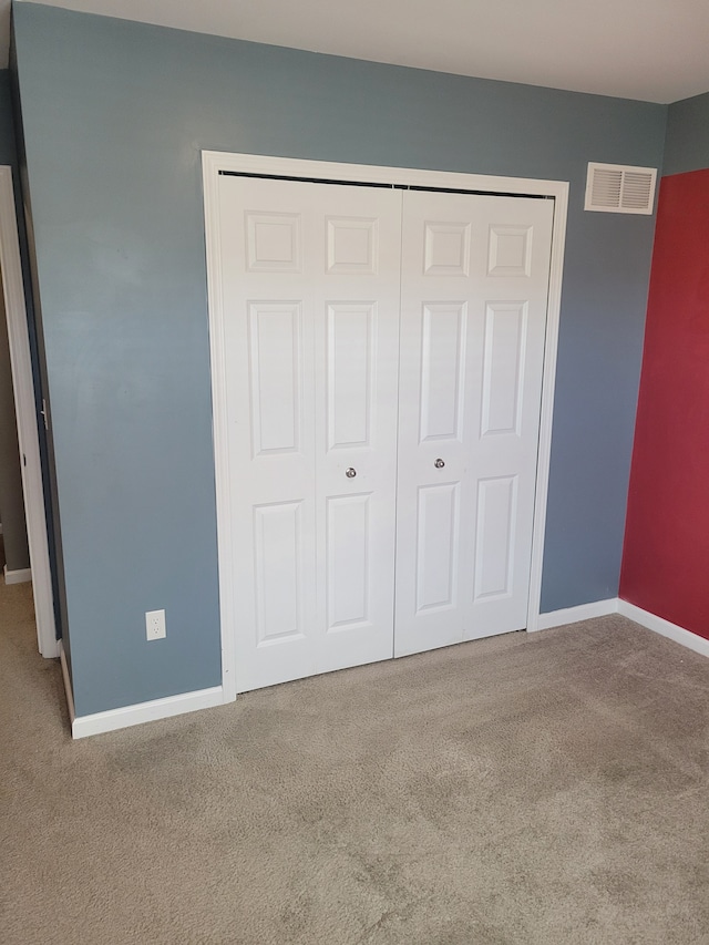 unfurnished bedroom featuring a closet and carpet floors