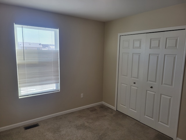 unfurnished bedroom with a closet and light carpet