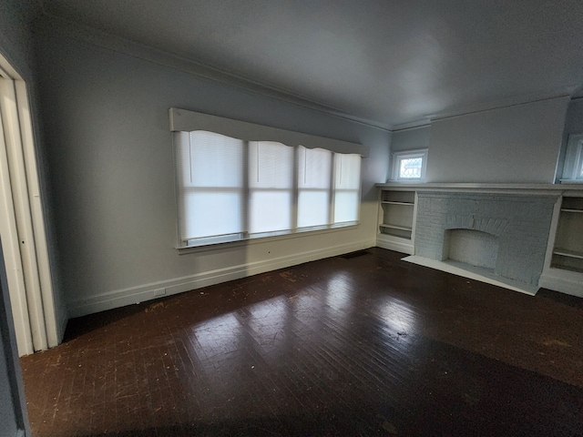 unfurnished living room featuring a fireplace, dark hardwood / wood-style floors, and ornamental molding