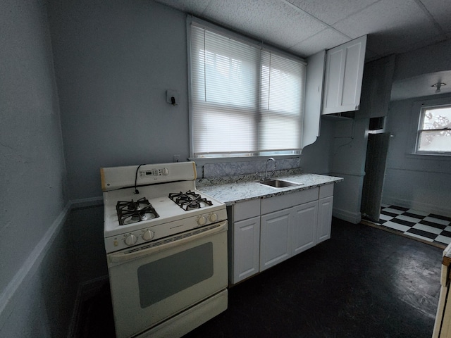 kitchen with a paneled ceiling, white cabinetry, sink, and white range with gas cooktop