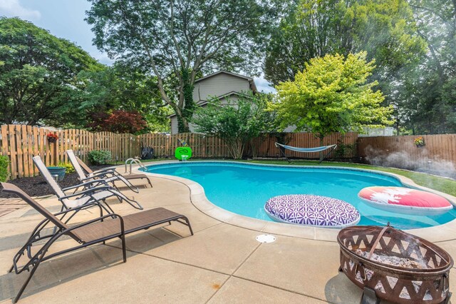 view of swimming pool featuring a patio area and an outdoor fire pit