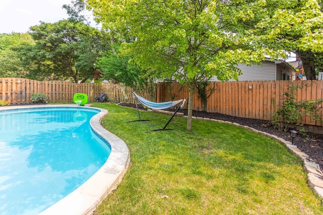 view of pool with a lawn