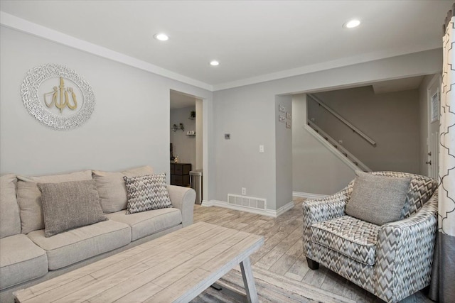 living room featuring light wood-type flooring and ornamental molding