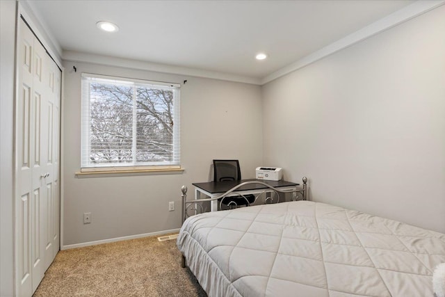 carpeted bedroom featuring a closet and ornamental molding