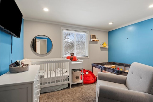 bedroom featuring a nursery area and carpet floors