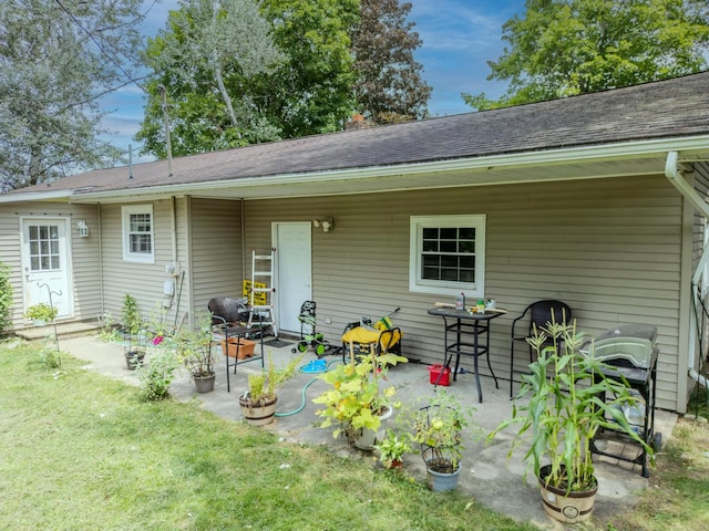 back of property featuring a lawn and a patio