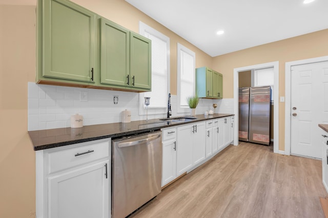 kitchen with sink, green cabinets, white cabinetry, stainless steel appliances, and light hardwood / wood-style floors