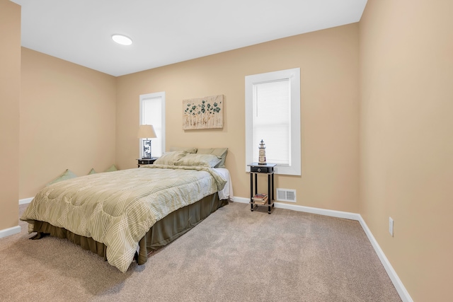 carpeted bedroom featuring multiple windows