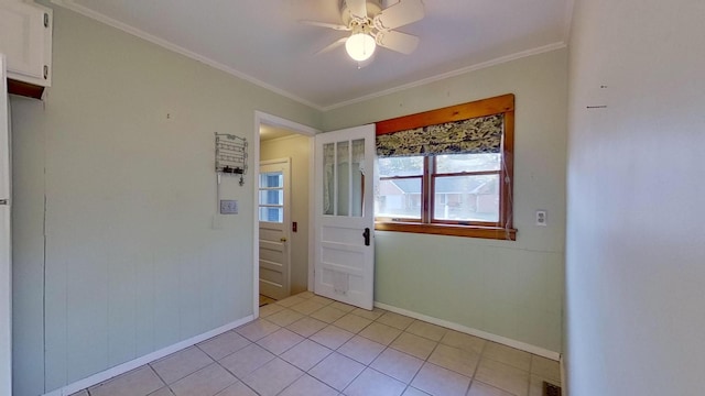 tiled empty room featuring ornamental molding and ceiling fan