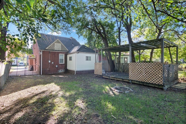 rear view of house featuring a pergola and a wooden deck