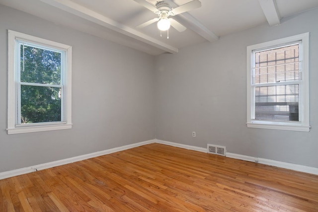 unfurnished room featuring beamed ceiling, light hardwood / wood-style flooring, and ceiling fan