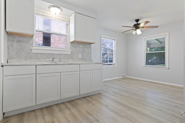 kitchen featuring ceiling fan, sink, light hardwood / wood-style flooring, decorative backsplash, and white cabinets