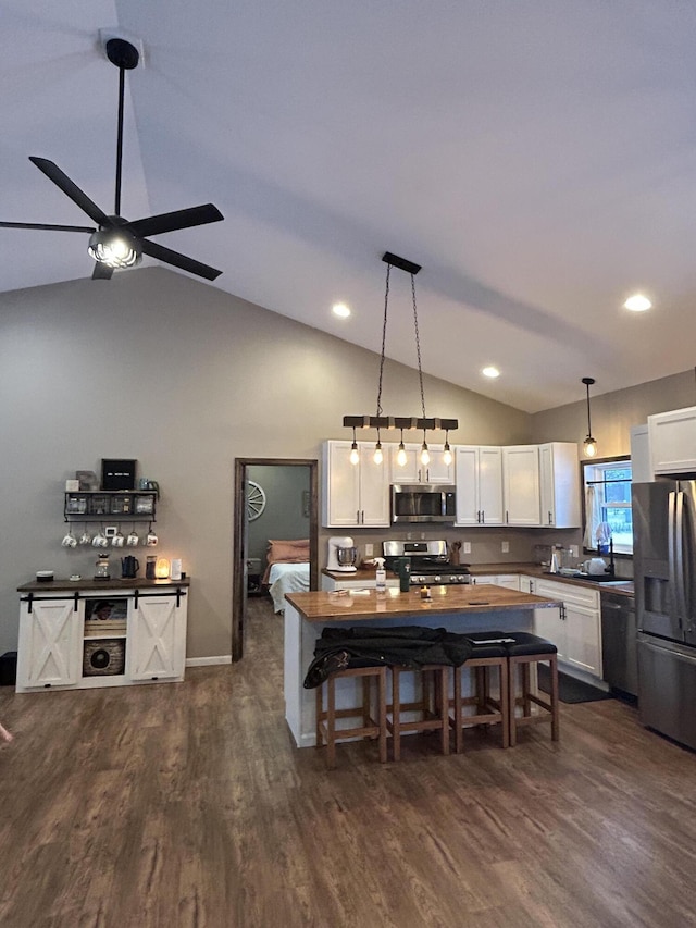 kitchen featuring pendant lighting, stainless steel appliances, dark wood-type flooring, and white cabinets