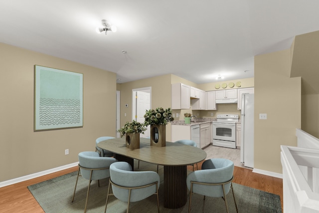 dining area featuring light wood-type flooring and sink