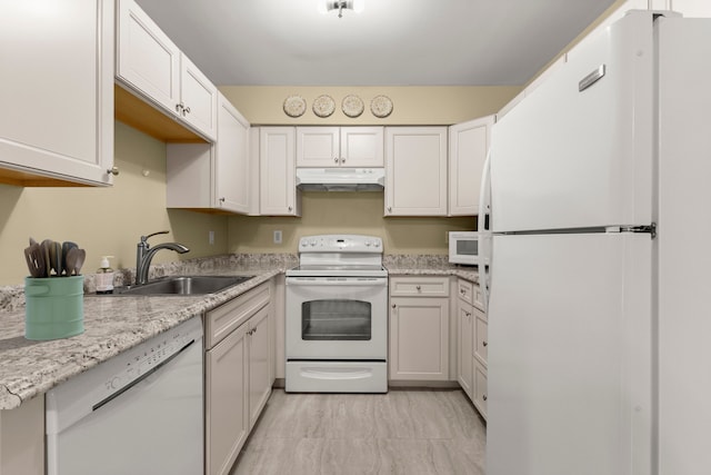 kitchen with white cabinets, light stone counters, white appliances, and sink