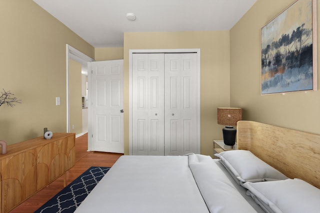 bedroom with dark hardwood / wood-style flooring and a closet